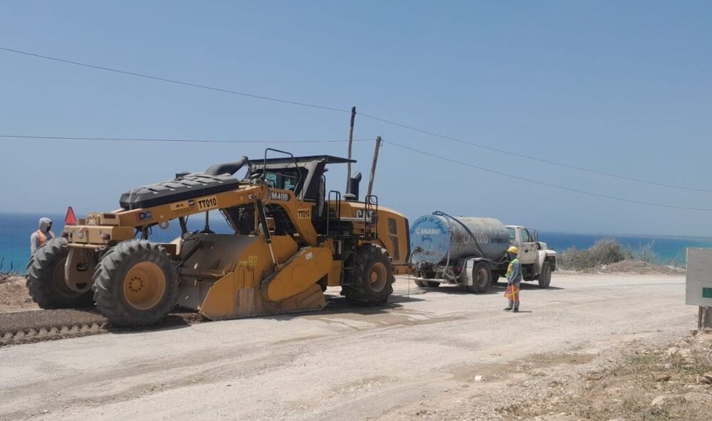 Comunitarios de Enriquillo alertan sobre el riesgo de una carretera construida cerca de un acantilado y piden revisar el trazado de la vía.